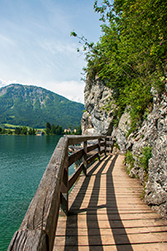 Entlang des Sees geht es auf einem Holzsteg
